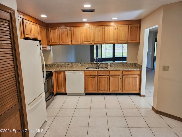 kitchen featuring sink, light stone countertops, white appliances, and light tile patterned flooring