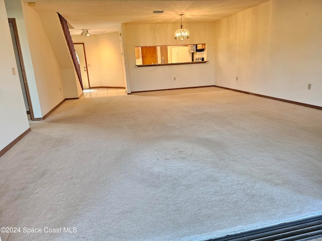 carpeted spare room featuring a chandelier