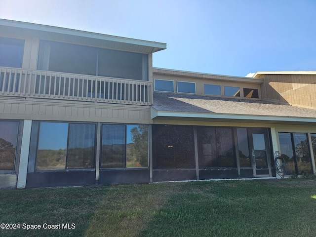 back of house featuring a yard and a sunroom