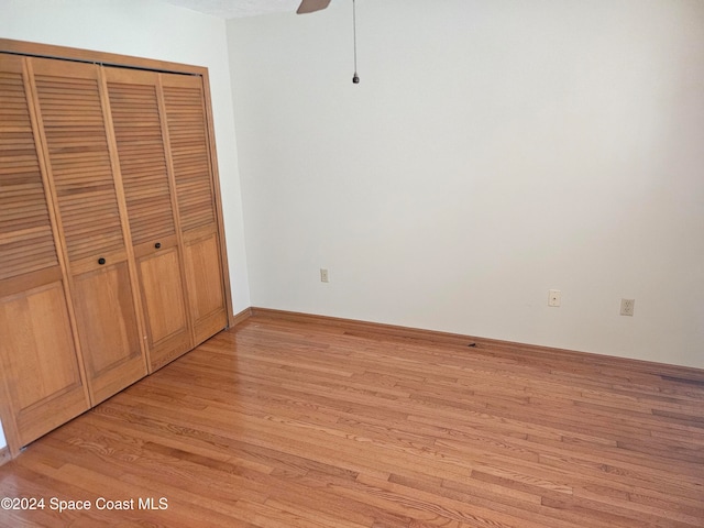 unfurnished bedroom featuring light hardwood / wood-style flooring, a closet, and ceiling fan