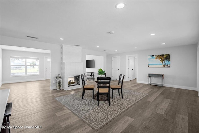 dining area featuring a fireplace and wood-type flooring