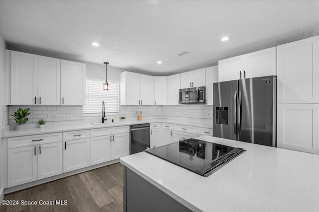 kitchen featuring decorative light fixtures, white cabinets, stainless steel appliances, and sink