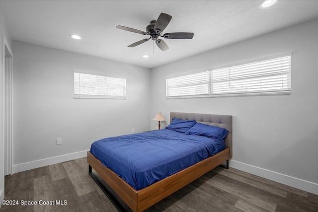 bedroom featuring dark wood-type flooring, ceiling fan, and multiple windows