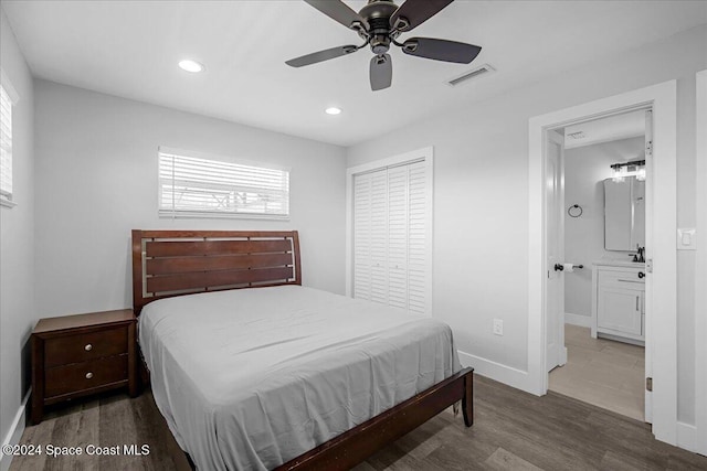 bedroom with a closet, hardwood / wood-style floors, ensuite bath, and ceiling fan