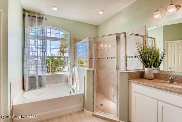 bathroom with vanity, vaulted ceiling, and separate shower and tub