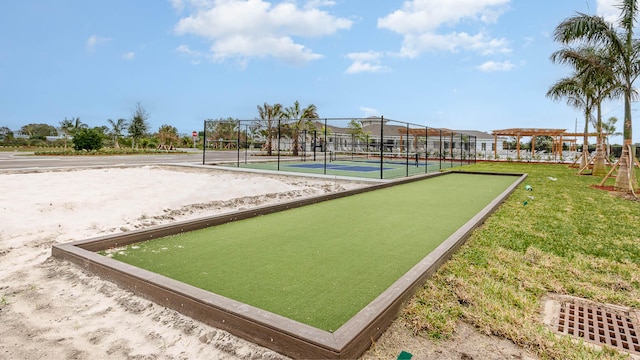 view of home's community with a lawn and tennis court