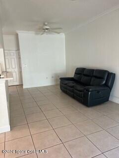 living room featuring crown molding, ceiling fan, and light tile patterned floors