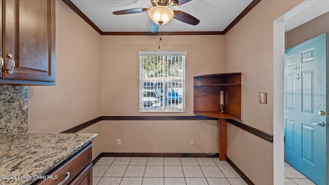 kitchen featuring crown molding, light stone countertops, ceiling fan, and light tile patterned floors