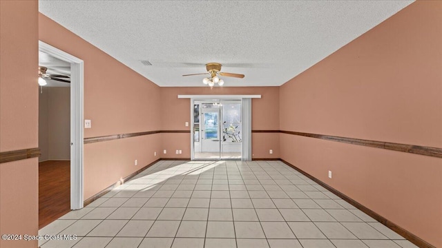 spare room with a textured ceiling, light wood-type flooring, and ceiling fan