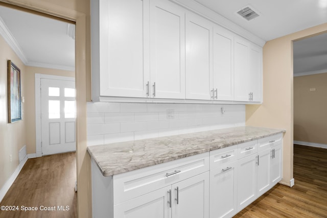 kitchen with light stone countertops, light hardwood / wood-style flooring, and white cabinetry