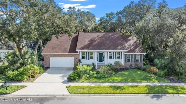 new england style home with a front yard and a garage