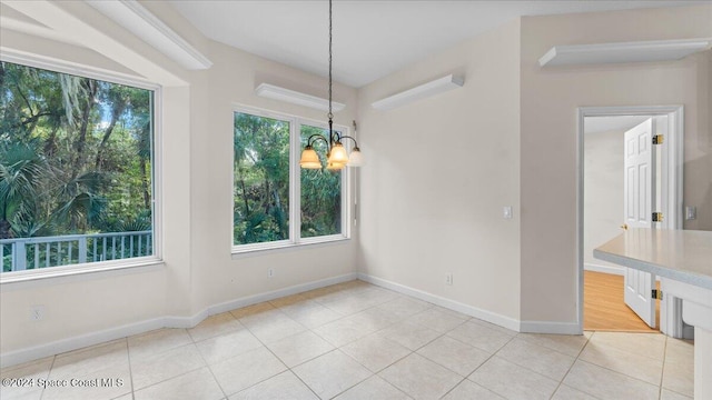 unfurnished dining area with light tile patterned flooring and an inviting chandelier