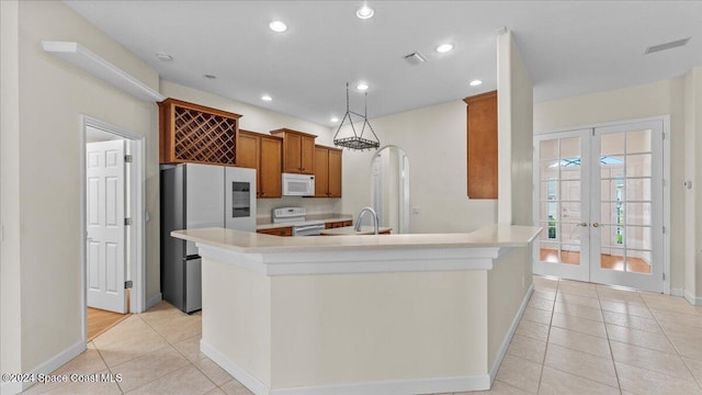 kitchen with french doors, sink, light tile patterned floors, and white appliances