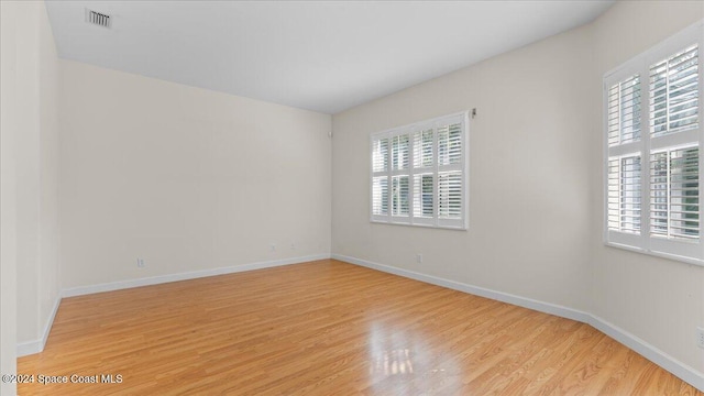 empty room with light hardwood / wood-style floors and a healthy amount of sunlight