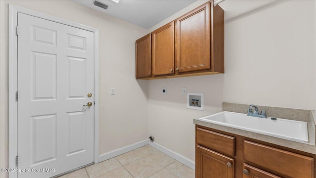 laundry area featuring washer hookup, hookup for an electric dryer, sink, light tile patterned floors, and cabinets