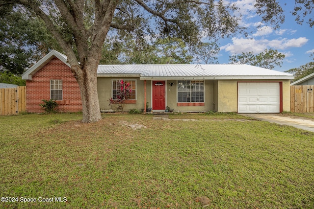 single story home with a garage and a front lawn