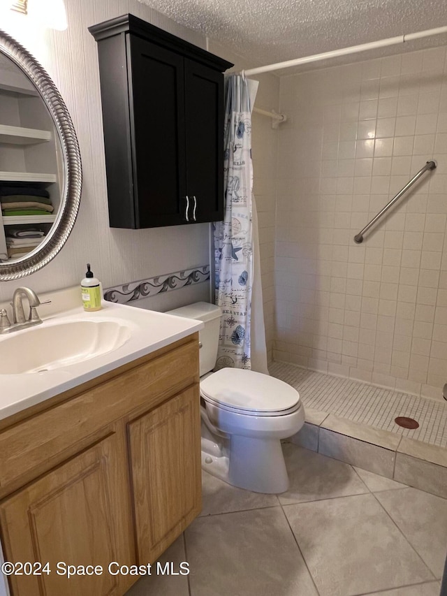 bathroom with tile patterned floors, toilet, a shower with curtain, vanity, and a textured ceiling