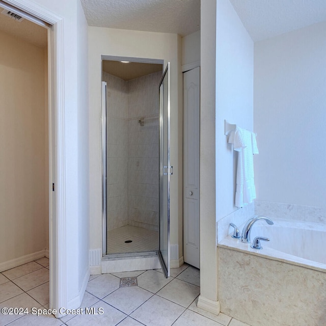 bathroom featuring tile patterned flooring, a textured ceiling, and plus walk in shower