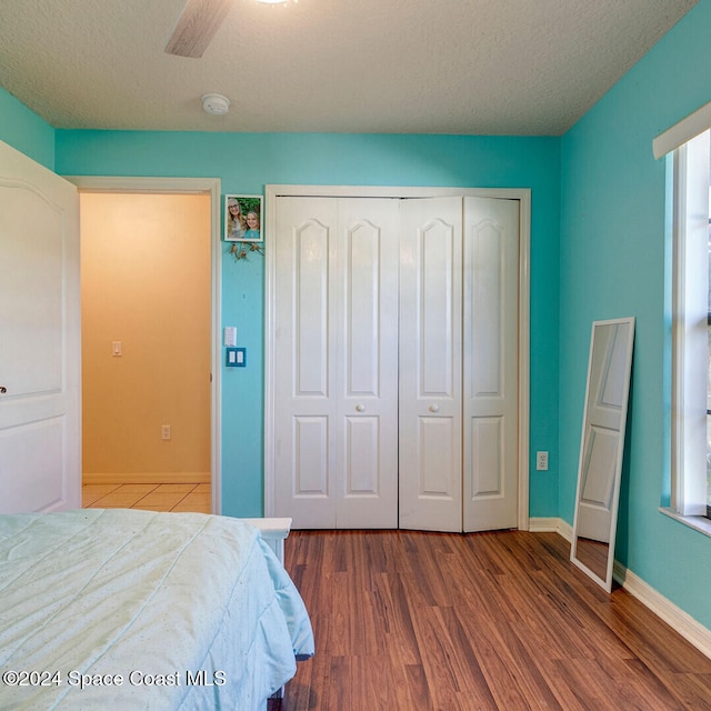 bedroom with ceiling fan, a closet, and hardwood / wood-style flooring