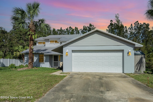 view of front of home featuring a garage and a yard