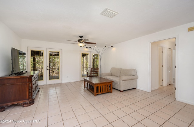 tiled living room featuring ceiling fan and french doors