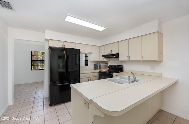 kitchen featuring sink, black appliances, kitchen peninsula, and cream cabinets