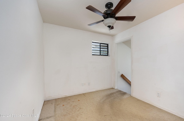 carpeted spare room with ceiling fan