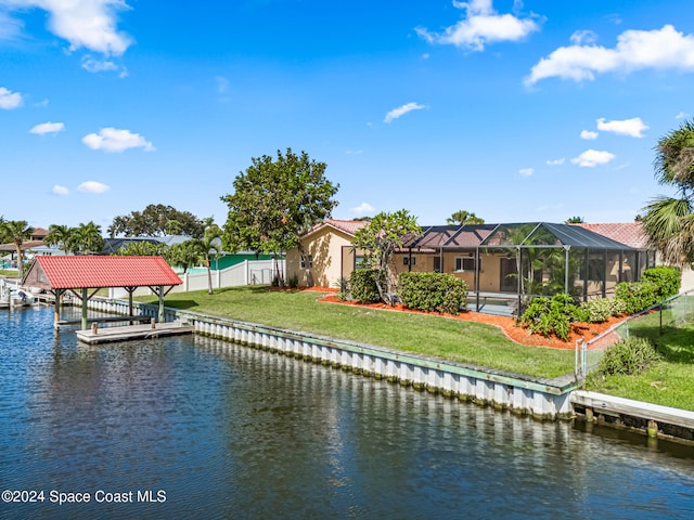 view of dock with a water view, a yard, and glass enclosure