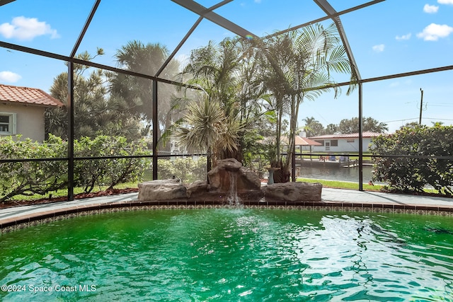 view of swimming pool featuring a water view and a lanai