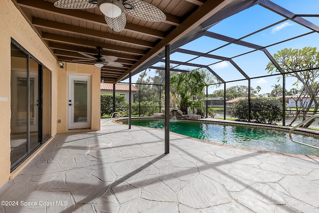 view of pool featuring ceiling fan, glass enclosure, and a patio area