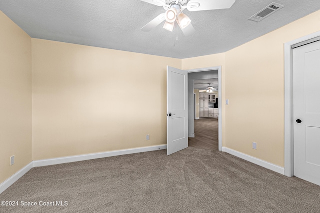 unfurnished bedroom featuring ceiling fan, carpet floors, and a textured ceiling