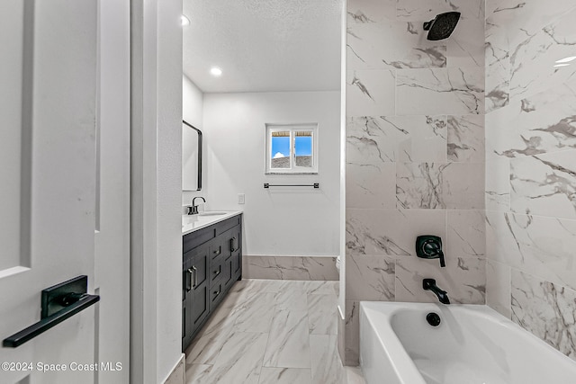 bathroom featuring vanity, tiled shower / bath combo, and a textured ceiling