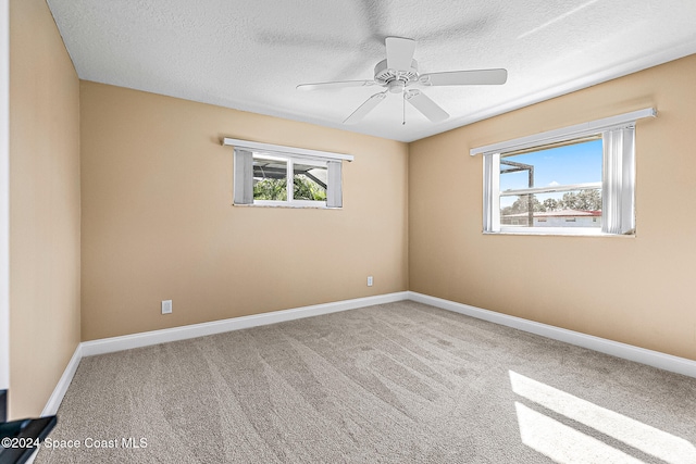 carpeted spare room with ceiling fan and a textured ceiling