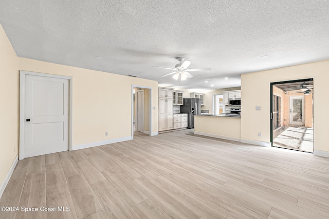 unfurnished living room with a textured ceiling, light hardwood / wood-style floors, and ceiling fan