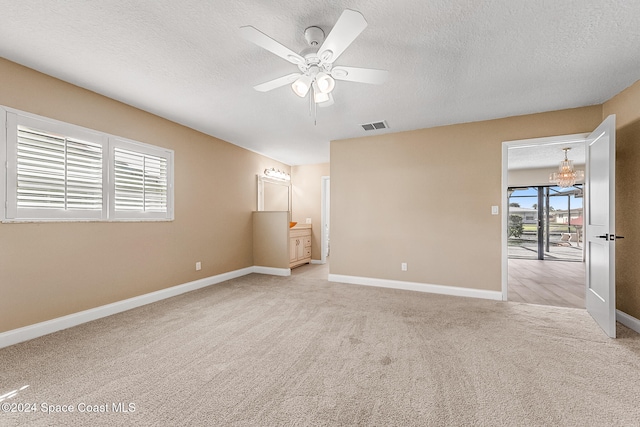 unfurnished bedroom featuring connected bathroom, ceiling fan, light colored carpet, and a textured ceiling