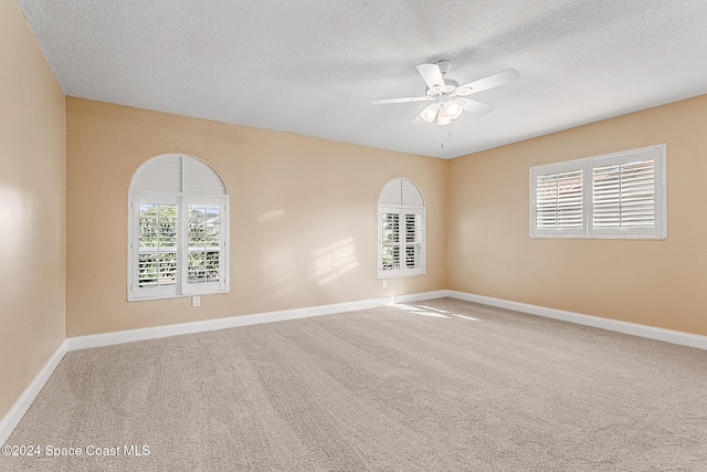 carpeted empty room featuring a textured ceiling and ceiling fan