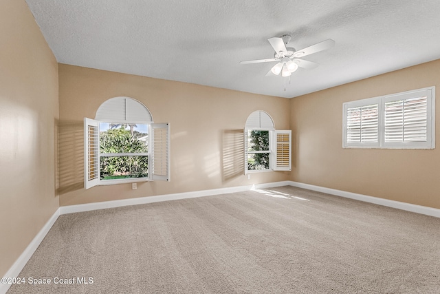 spare room featuring a textured ceiling, carpet floors, and ceiling fan