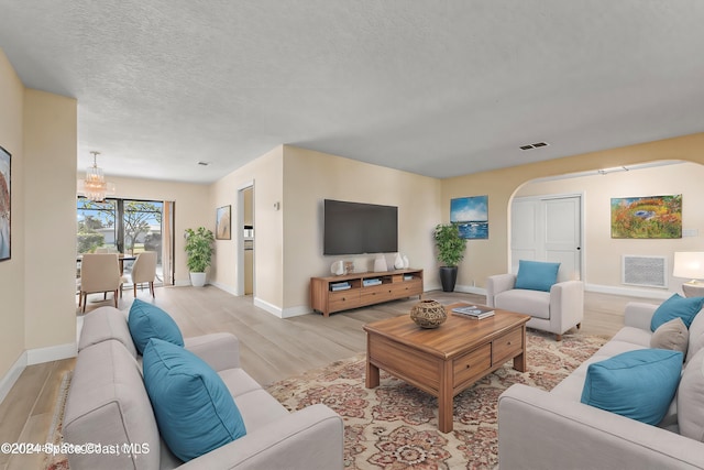 living room featuring a textured ceiling and light hardwood / wood-style floors