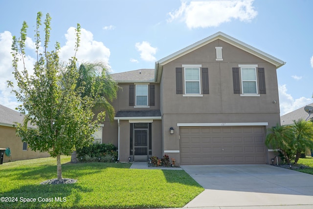 view of front of property with a front lawn and a garage