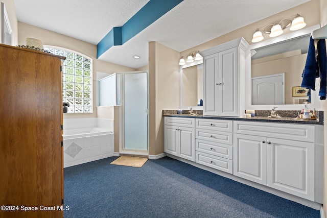 bathroom with vanity, separate shower and tub, and a textured ceiling