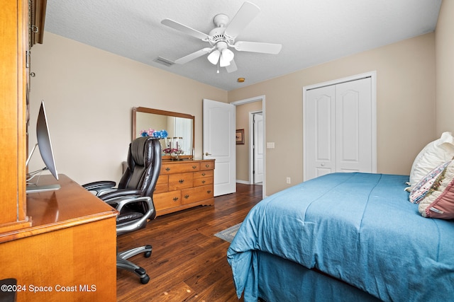 bedroom featuring a closet, dark hardwood / wood-style floors, a textured ceiling, and ceiling fan