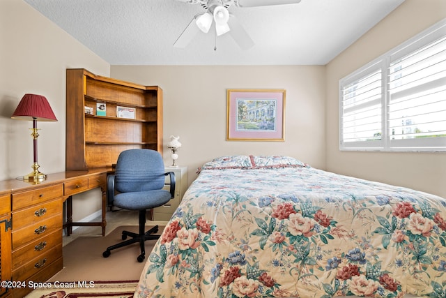 bedroom with ceiling fan, a textured ceiling, and carpet floors