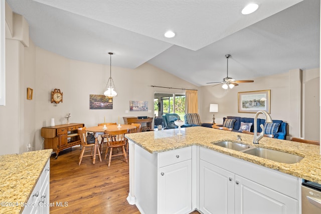 kitchen featuring sink, light wood-type flooring, dishwasher, white cabinetry, and lofted ceiling