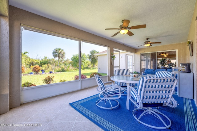 sunroom featuring ceiling fan and plenty of natural light