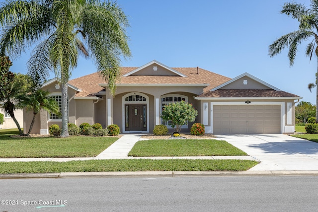 single story home featuring a front lawn and a garage