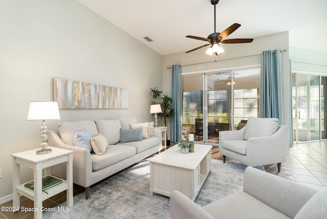 living room featuring ceiling fan, light tile patterned floors, and vaulted ceiling