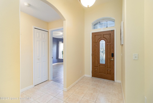 tiled foyer featuring plenty of natural light and ceiling fan