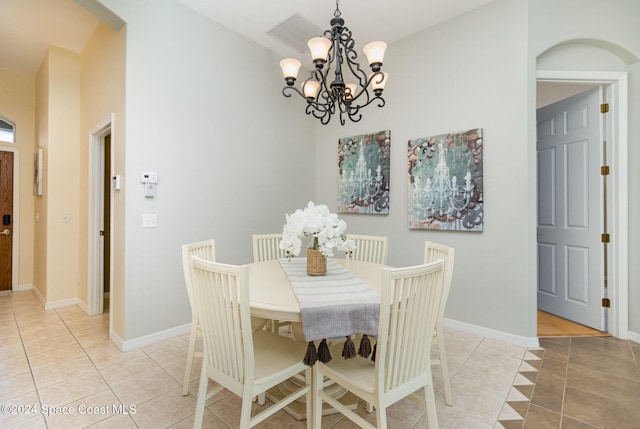 tiled dining area with a chandelier