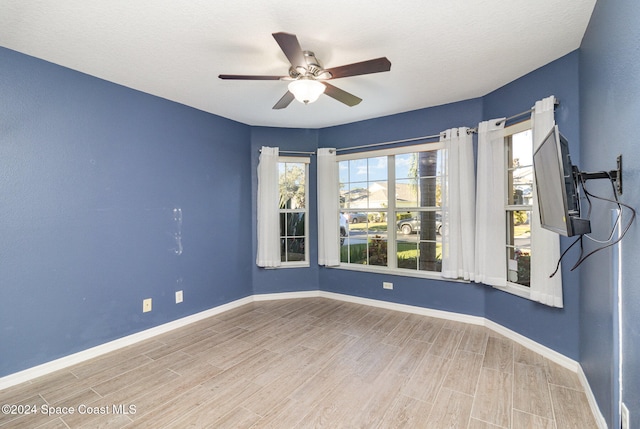 empty room featuring hardwood / wood-style floors, ceiling fan, and a textured ceiling