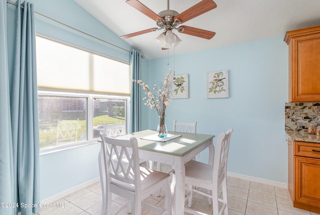 dining space featuring light tile patterned floors, vaulted ceiling, and ceiling fan